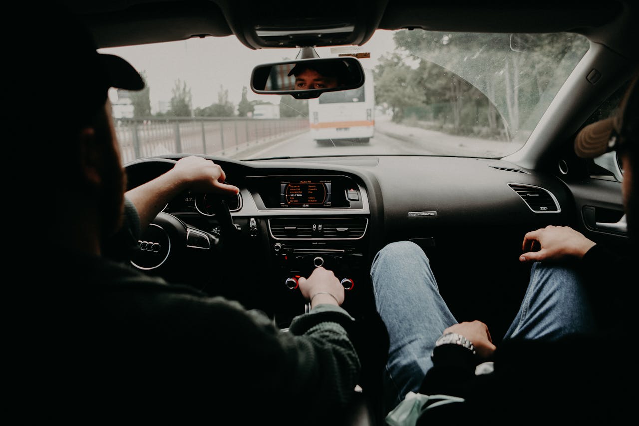 View from inside a moving car with two men traveling on a road trip.